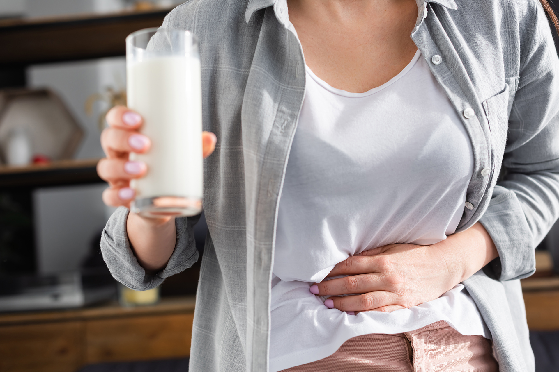 donna con intolleranza al lattosio che beve un bicchiere di latte