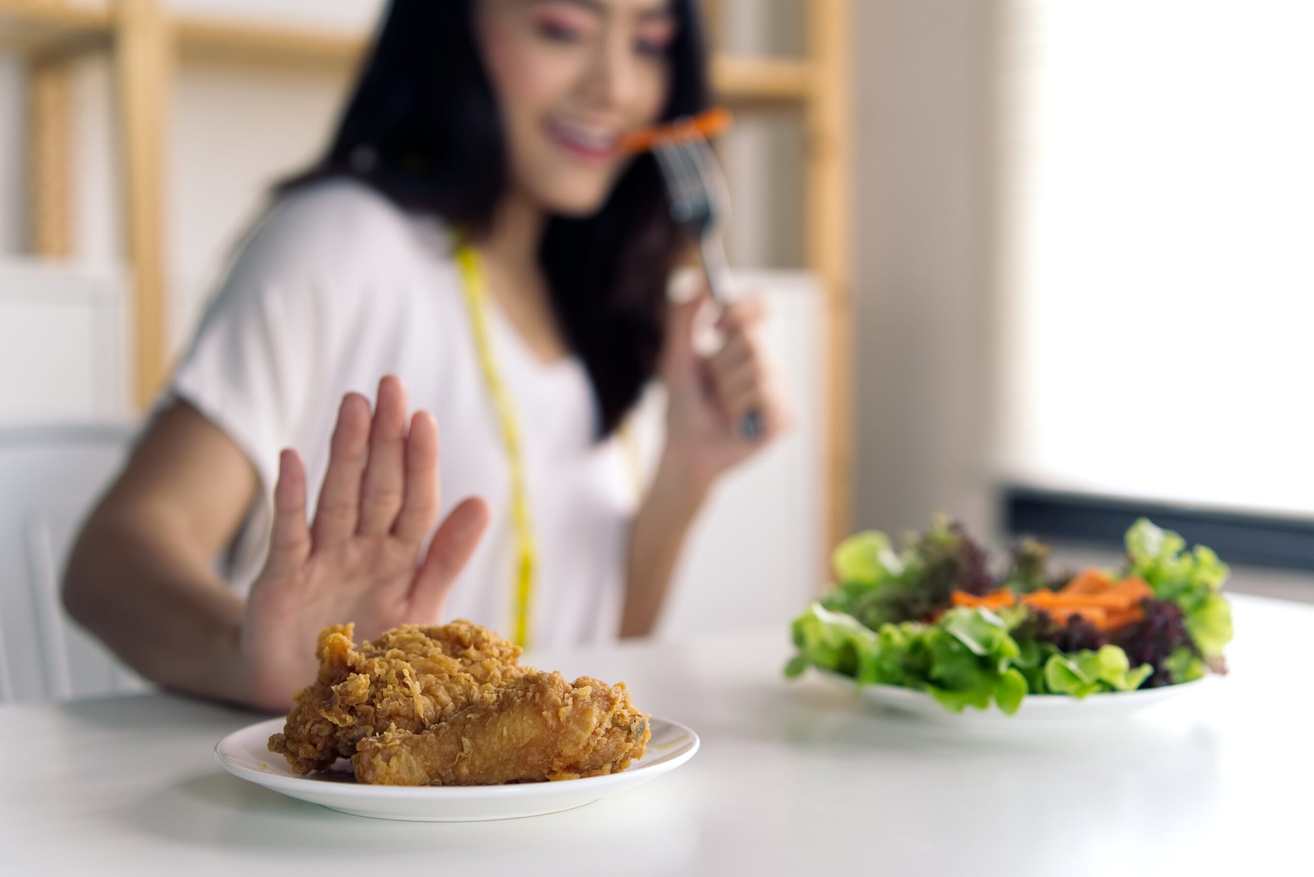 donna mangia insalata e rifiuta junk food