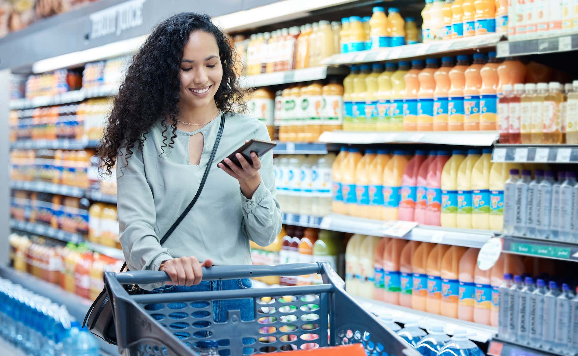 donna fa la spesa e compra cibo con l'aiuto della tecnologia dello smartphone