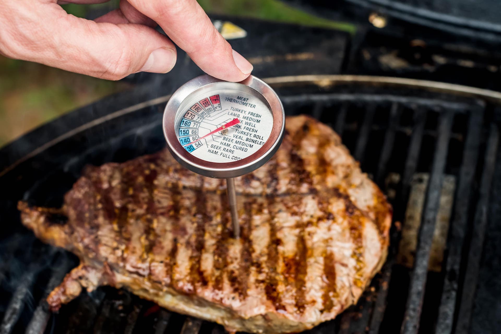 mano con termometro per carne che controlla la cottura per una buona sicurezza alimentare in cucina